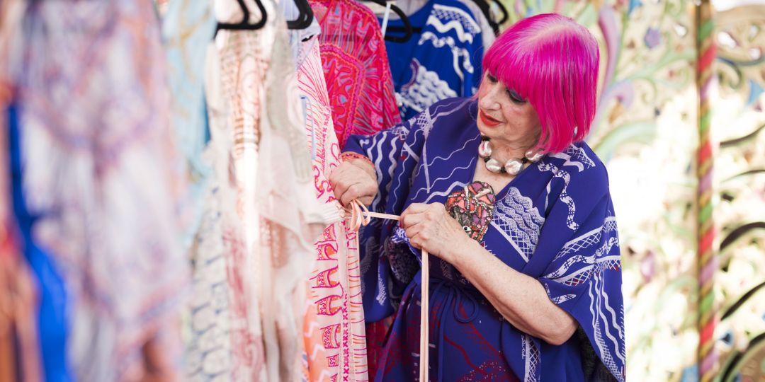 Portrait of Zandra Rhodes tying a dress.